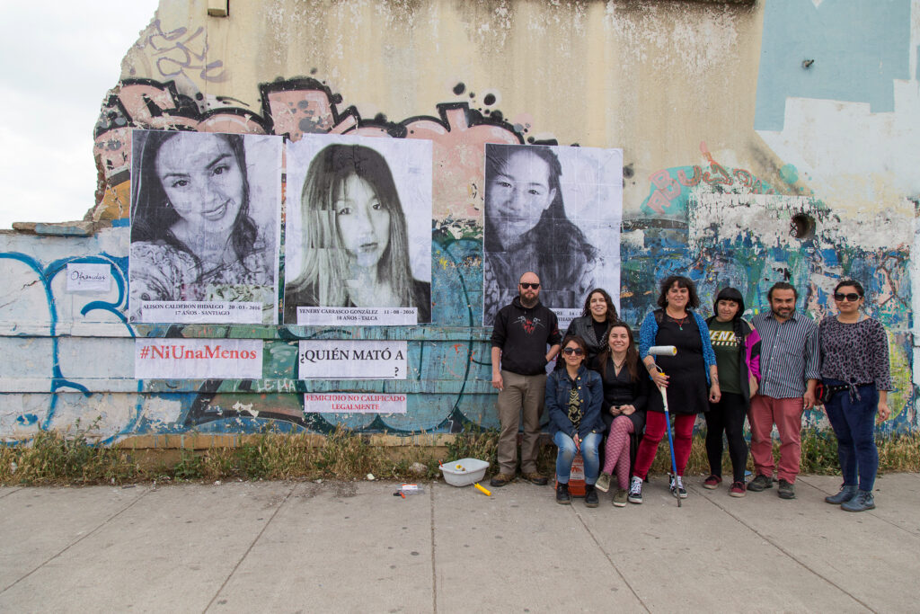 Grupo de 8 personas junto a gigantografias de mujeres jóvenes asesinadas en el año 2016: Alison Calderon Hidalgo 17 años - Santiago de Chile y Yenery Carrasco González 18 años - Talca y Florencia Aguirre 9 años - Coyhaique.